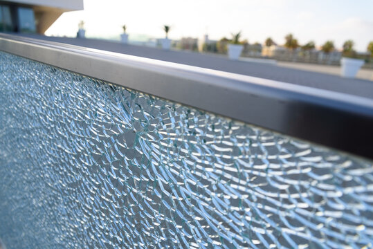 A glass fence, broken and broken by a blow, glass shattered.