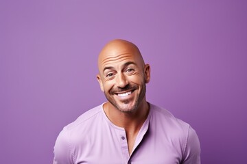 Portrait of a happy mature man smiling at camera against purple background