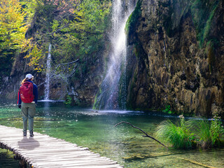 person walking by a waterfall in the plitvice lakes national park