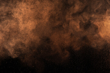 Orange powder explosion on black background. Flame cloud. Yellow dust explode. Freeze motion paint...