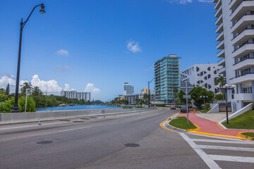 Beautiful urban landscape of Miami Beach on sunny summer day. Road runs along waterfront with tall modern buildings on other side. USA.