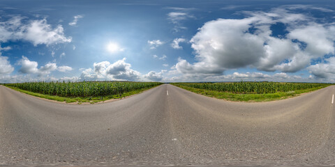 spherical 360 hdri panorama on old asphalt road among corn fields with clouds and sun on blue sky in equirectangular seamless projection, as skydome replacement in drone panoramas, game development - obrazy, fototapety, plakaty