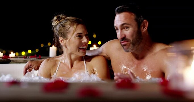 Love, hot tub and couple laughing, talking and bonding on Valetines Day date, honeymoon or funny discussion. Romantic humour, comedy conversation and happy man, woman or people hug in night jacuzzi