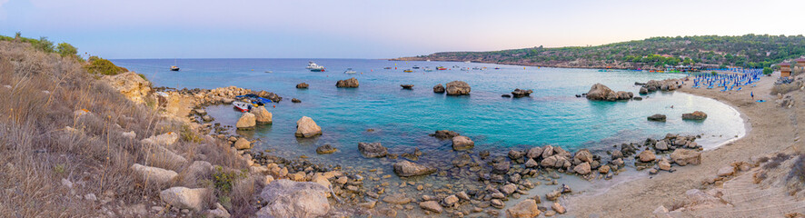 Konnos bay beach in Cyprus next to the Mediterranean Sea in the late afternoon with pleasure boats...