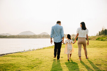 A young girl running through a meadow of flowers under a sunny sky, with a big smile on her face and a feeling of freedom and happiness, family day