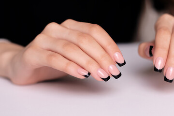 Beautiful female hands with fashion manicure nails, black gel polish
