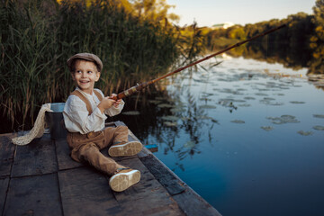 Little boy fishing at sunset