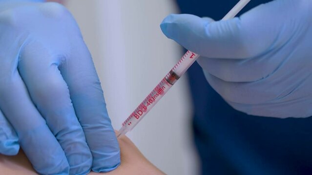 close-up of a doctor administering a vaccine to a patient or giving an immunization at a hospital