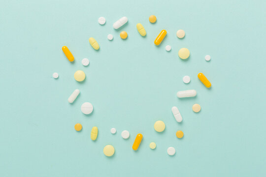 Different pills on color background, top view