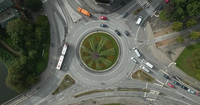 drone footage of a roundabout in "L&uuml;beck" with a green garden in the middle 