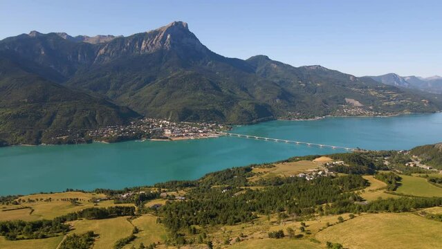 Aerial morning view of Serre-Poncon lake with Savines-le-Lac village and Grand Morgon peak. Durance Valley in summer. Hautes-Alpes (Alps), France