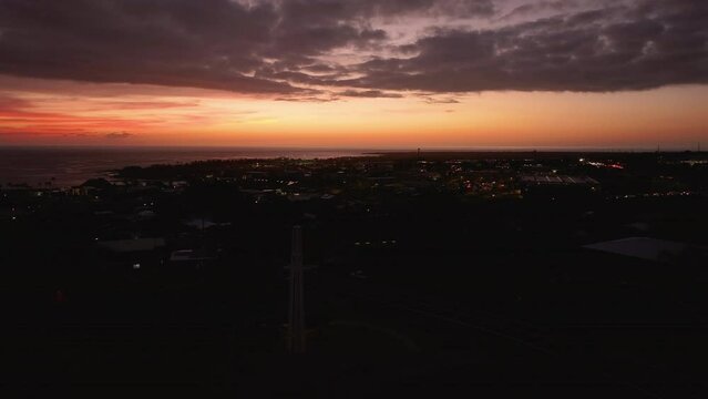 Aerial Kona Hawaii city dark sunset cityscape. Big Island. Luxury exclusive resorts and homes on coast with tropical landscape. Economy is tourism based. Water and tropical beach recreation and fun.