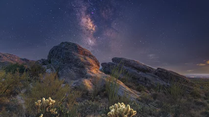 Tuinposter The Milky Way galaxy rising over a lone rocky desert © Eric