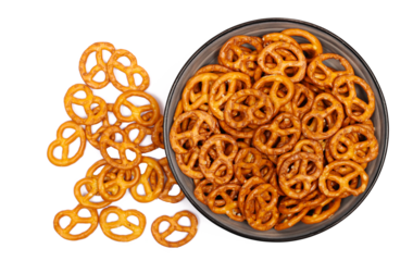 Salted pretzels pile, party snacks in bowl isolated on white, top view
