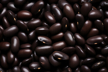 A detailed close-up of a heap of black or dark brown beans.Generative AI