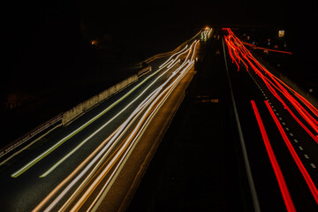 Abstract image of night traffic lights on the road. Car light trails at night in curve asphalt...