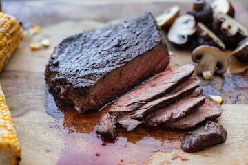 cut juicy medium rare grilled steak on wooden board 