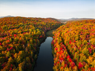 Naklejka premium Aerial view of winding river in Laurentian mountains, Quebec, Canada during the fall foliage