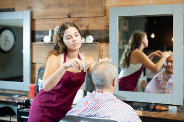 Female master barber does the hairstyle and styling. Concept barbershop