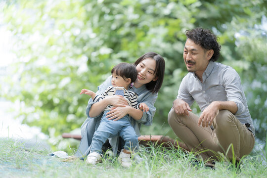 公園で遊ぶ幸せなアジア系（日本人）の家族 新緑の季節春夏のイメージ