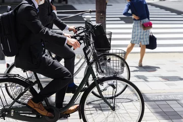 Foto op Canvas Japanese business men on bicycles on the sidewalk in Tokyo © Christian Müller