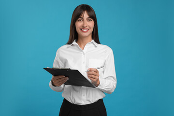 Happy secretary with clipboard and pen on light blue background