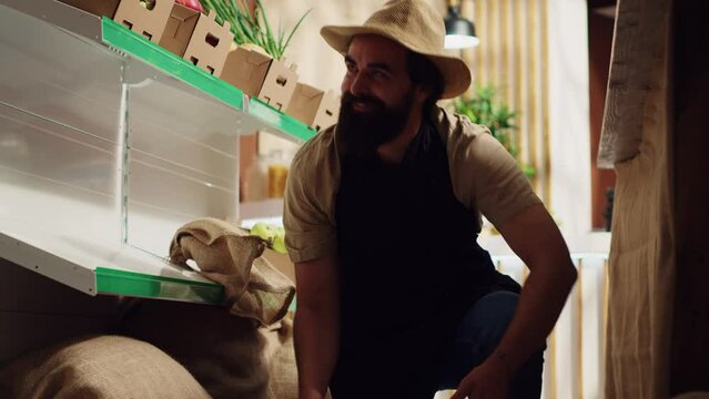 Farmer bringing boxes of fresh produce, restocking local neighborhood grocery shop with vegetables from his own farm. Trader supplying zero waste store with natural food, making client happy