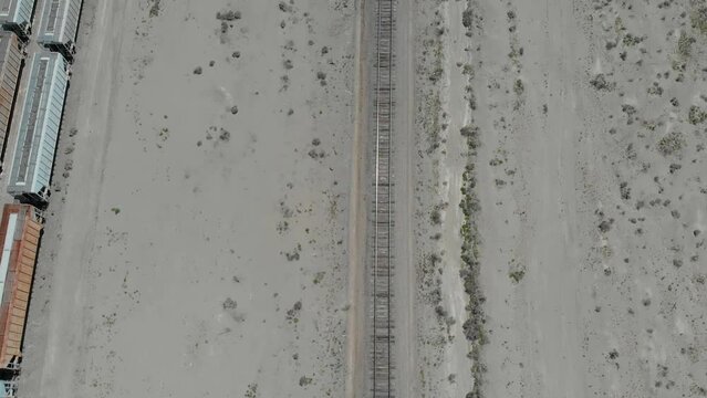 Drone flying accross the railroad of the trona pinnacles in the california desert at sunrise 4k