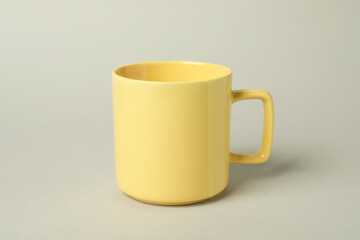 One yellow ceramic mug on light grey background