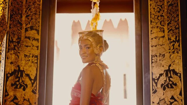 Woman In A Chut Thai Standing Near Ornate Window