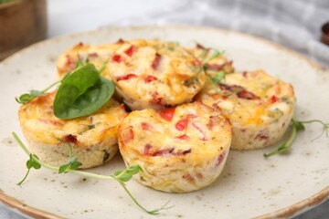 Freshly baked bacon and egg muffins with cheese on plate, closeup