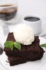 Tasty brownies served with ice cream and mint on table, closeup