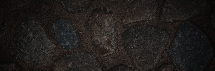 Ground texture with large stones. Old pavement of granite boulders. Stone decoration of sidewalks...