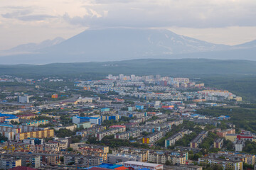 Morning cityscape. Top view of the buildings and streets of the city. Residential urban areas at sunrise. Koryaksky volcano in the distance. Petropavlovsk-Kamchatsky, Kamchatka Krai, Russian Far East.