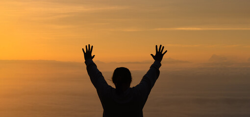 Woman raising his hands in worship. Christian Religion concept. Silhouette woman on sunrise background. Christian female prayers to God in faith. Women raise hands in praise with faith and peace. - obrazy, fototapety, plakaty