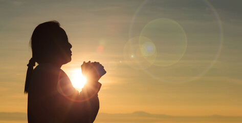 Woman raising his hands in worship. Christian Religion concept. Silhouette woman on sunrise...