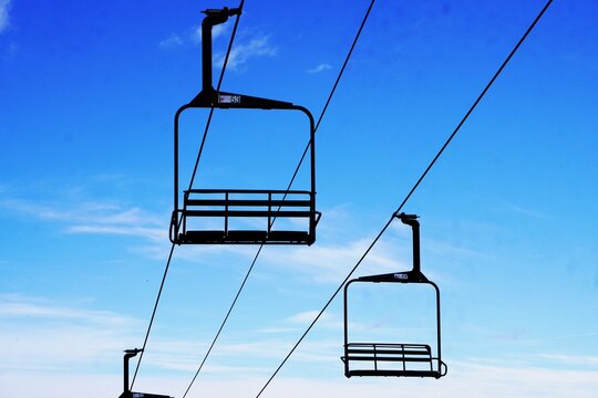 Chair lift above a hillside with a blue sky, Ski lift chairs 
