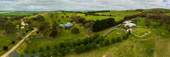 Aerial afternoon panorama views over rural properties with cloudy sky
