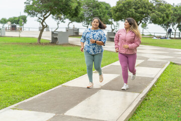 Naklejka na ściany i meble Overweight women jogging along an urban park