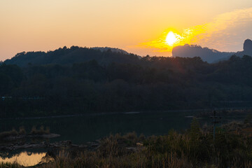 The sun setting down behind the distant mountains in Wuyishan, Fijian, China