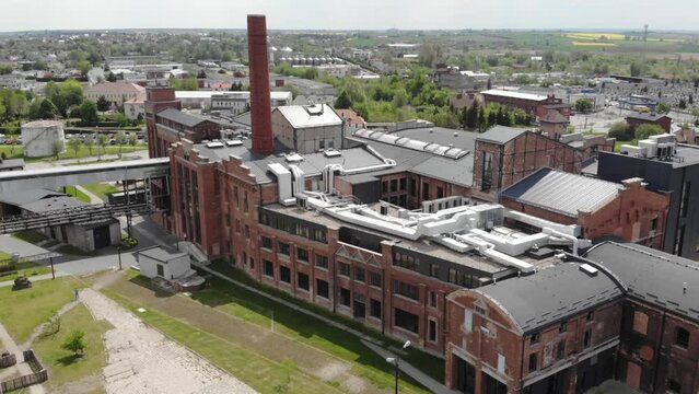Aerial tilt-down shot of the chimney in Arche Hotel Żnin inside old sugar factory in Poland. The tall chimney of the factory is a famous landmark, rising above the surrounding landscape