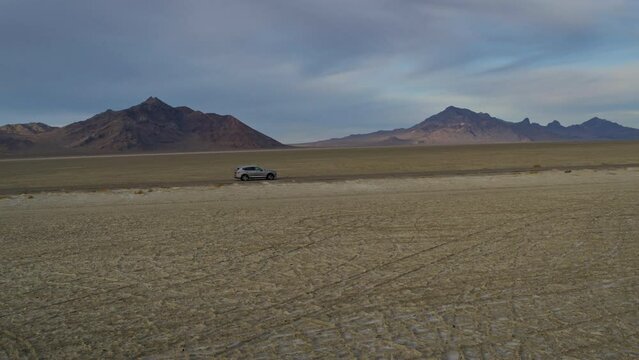 Epic shot of van driving down empty desert road - tracking shot