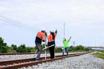 Engineer use theodolite equipment and Blueprint surveying construction worker on Railway site..