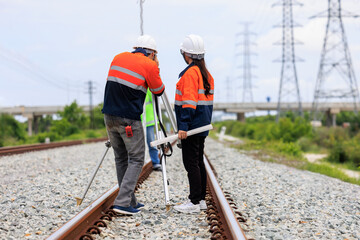 Engineer use theodolite equipment and Blueprint surveying construction worker on Railway site..
