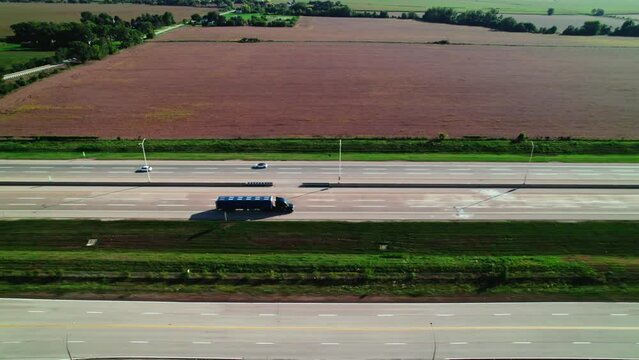 tracking aerial of a black Conestoga - flatbed Semi Trailer Truck driver driving on interstate. Great concept for hiring truck drivers or owner operators.