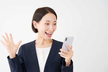 スマートフォンを持って驚くビジネスウーマン　白背景