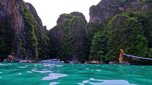 Phi Phi island off the coast of phuket thailand. Phi phi island is famous for turquoise clear blue waters teaming with Corel reef fish white soft sand and lush green trees.