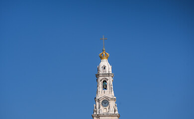 Fototapeta na wymiar Fatima Church basilica. The miracle place church from Fatima, Portugal, against blue clean sky, while the bells are ringing. Religious landmark monastery from Portugal.