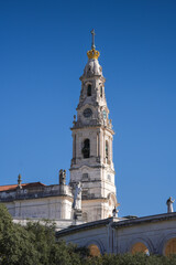 Fatima Church basilica. The miracle place church from Fatima, Portugal, against blue clean sky, while the bells are ringing. Religious landmark monastery from Portugal.