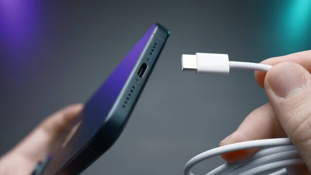 Close-up of type C wire for charging phone. Action. Type-C connector for charging phone on isolated ofn. New wire type C and included for phone